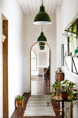 This light and airy hallway is given a natural pop of color by adding potted plants.